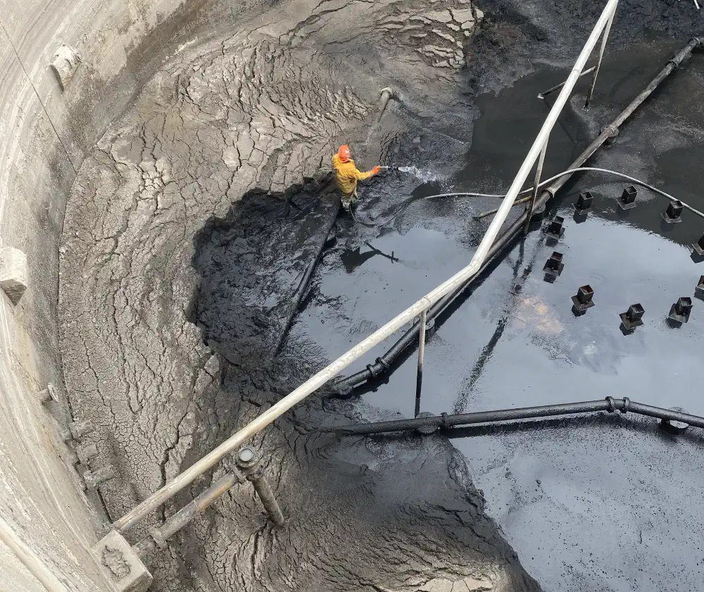 Staff cleaning a digester tank